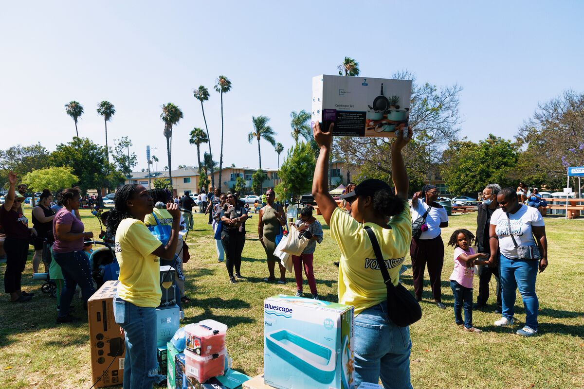 Volunteer holding up a prize box while crowd celebrates at the raffle giveaway
