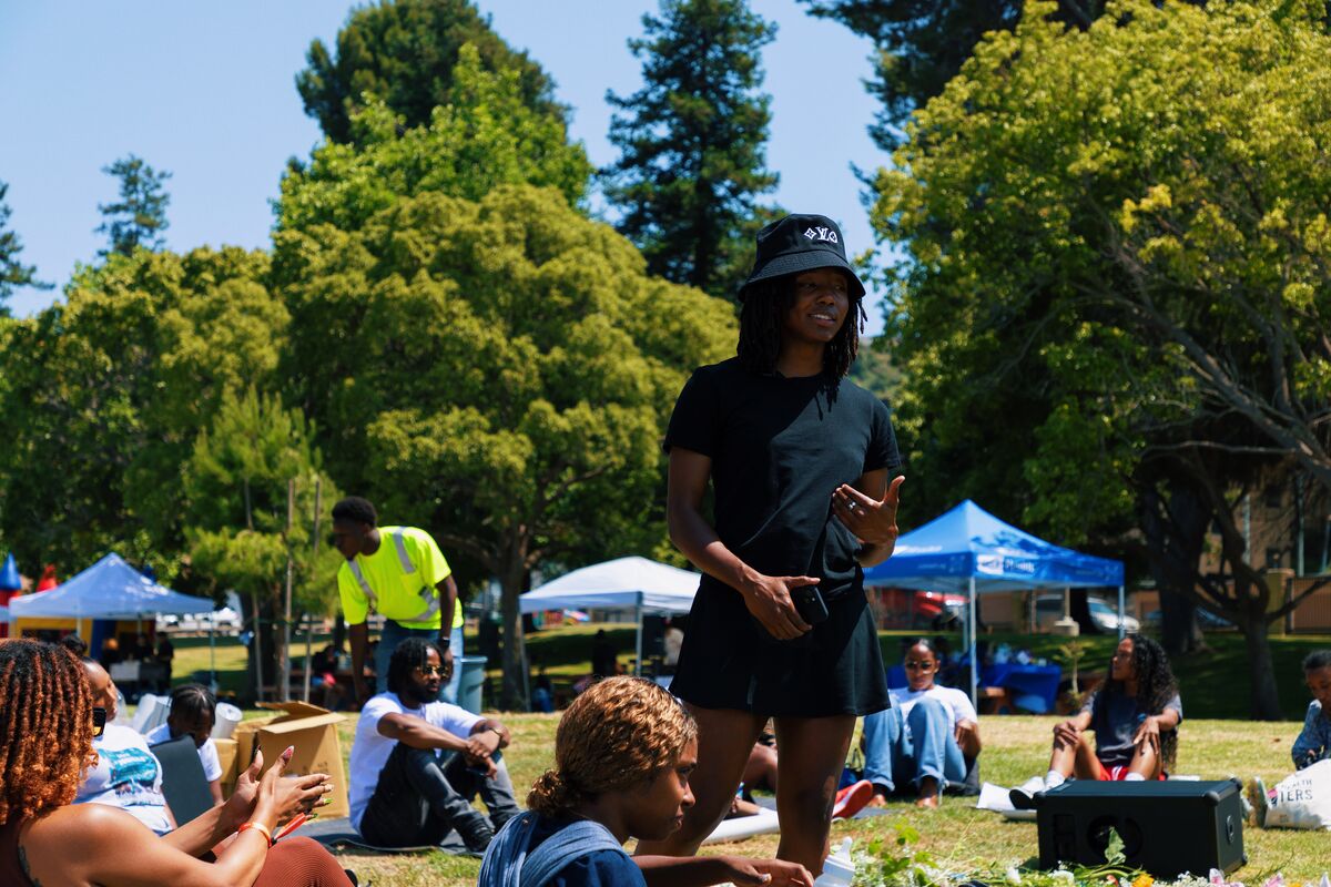 Healing circle facilitator speaking to seated community members in the park