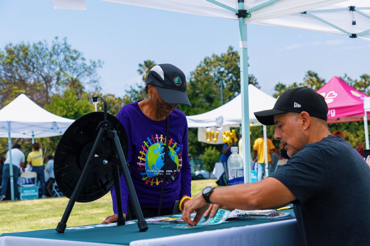 Community member playing the spinning wheel prize game at a partner booth